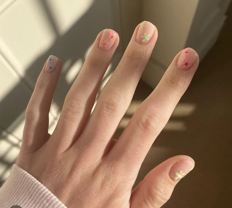 Bright pink nails with multicoloured flowers